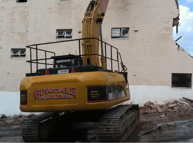 Demolishing a white brick building | Featured image for Commercial Demolition Brisbane page Gumdale Demolitions