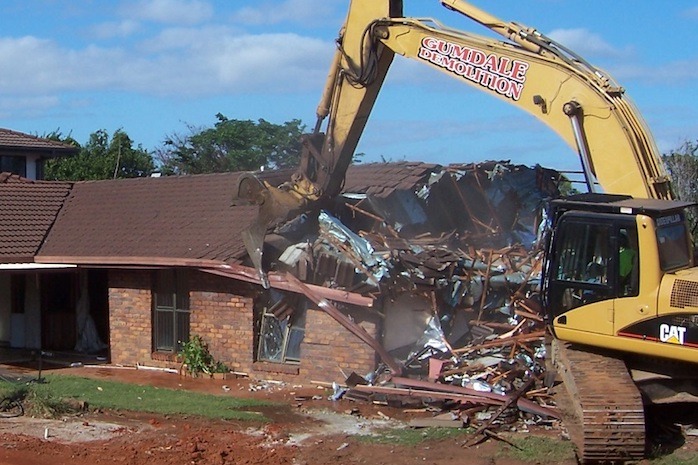 Photo of the Coles Rochedale - Residential Demolition Project - featuring a backhoe demolishing a home | Featured image for Coles, Rochedale.