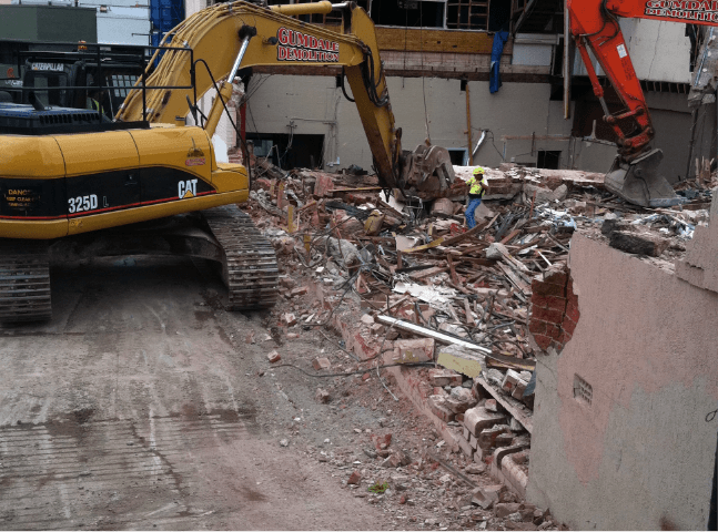 Man and machine demolishing a building | Featured image for Commercial Demolition Brisbane page Gumdale Demolitions