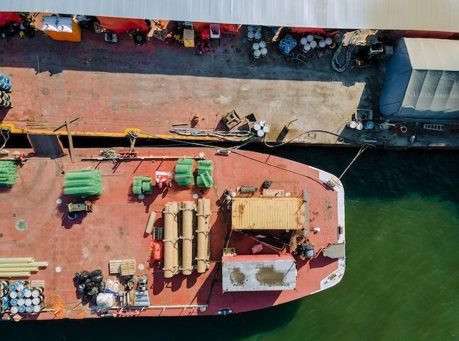 Barge docked next to a construction vessel | Featured image for Industrial Asbestos Removal Landing Page for Gumdale Demolition.