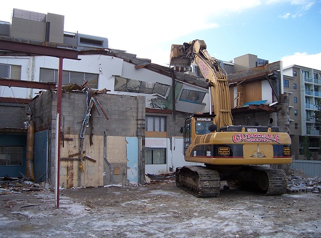 Demolishing a white building | Featured image for Industrial Demolition Brisbane page Gumdale Demolitions